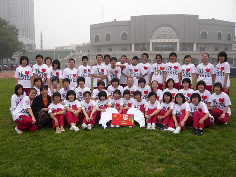 《我們都是一家人》——2009年9月29日學(xué)校運(yùn)動(dòng)會(huì)結(jié)束后,趙老師班級(jí)合影。
每個(gè)校園運(yùn)動(dòng)會(huì)上,從口號(hào)到隊(duì)服,總不乏學(xué)生們的創(chuàng)新。趙老師的同學(xué)們更是一個(gè)個(gè)如設(shè)計(jì)大師:校運(yùn)會(huì)的隊(duì)服上衣是同學(xué)們?yōu)閼c祝祖國(guó)60歲生日而設(shè)計(jì)。前面是“我愛(ài)四班”,“愛(ài)”字是個(gè)鮮艷的紅心。肩膀是他們自己設(shè)計(jì)的班徽,后面是五星紅旗。五星紅旗兩側(cè)是兩個(gè)彩色手印,代表祖國(guó)的騰飛。從設(shè)計(jì)到染色,都是全班同學(xué)自己動(dòng)手完成,每個(gè)同學(xué)均參與其中。