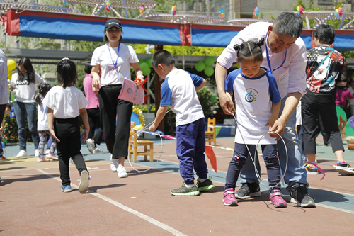 豐臺六幼的孩子們體驗推鐵環(huán)。