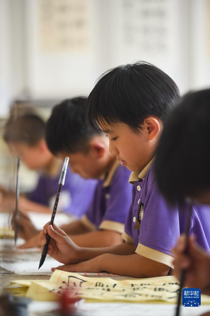 6月24日，在包頭市昆都侖區(qū)包鋼第十七小學(xué)，學(xué)生們利用課余時間學(xué)習(xí)書法。