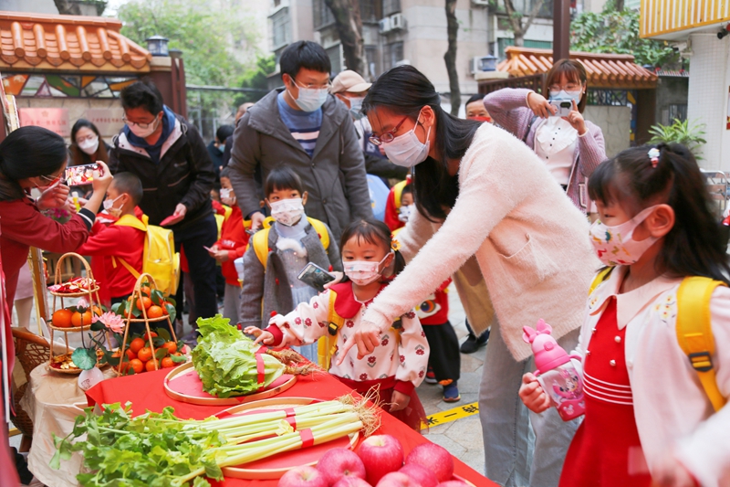 2月6日，廣州市番禺區(qū)北城幼兒園的家長(zhǎng)向孩子講解開(kāi)學(xué)摸生菜寓意“生生猛猛”的嶺南民俗。北城幼兒園供圖