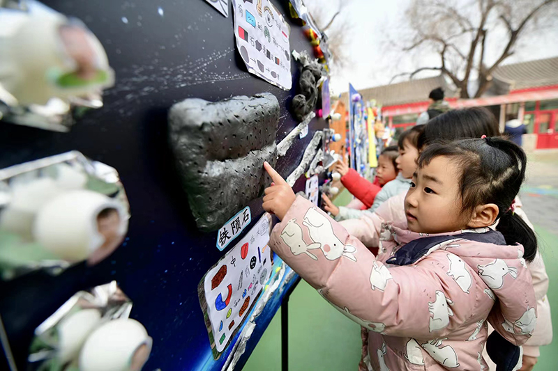 在北京市第一幼兒園吉祥魏家分園舉行第九屆“科學(xué)節(jié)”活動上，小朋友們正在觀察隕石。校方供圖