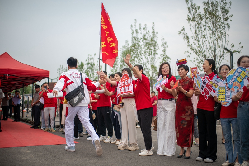 6月7日，在中國人民大學附屬中學通州校區(qū)考點，考生與送考老師擊掌加油。人民網(wǎng)記者 翁奇羽攝