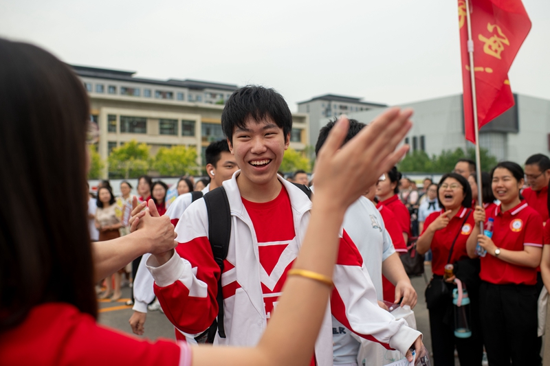 6月7日，在中國(guó)人民大學(xué)附屬中學(xué)通州校區(qū)考點(diǎn)，考生與送考老師擊掌加油。人民網(wǎng)記者 翁奇羽攝