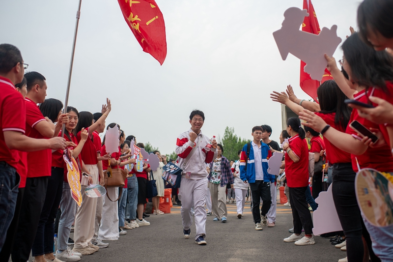 6月7日，在中國人民大學(xué)附屬中學(xué)通州校區(qū)考點，送考老師為考生加油。人民網(wǎng)記者 翁奇羽攝