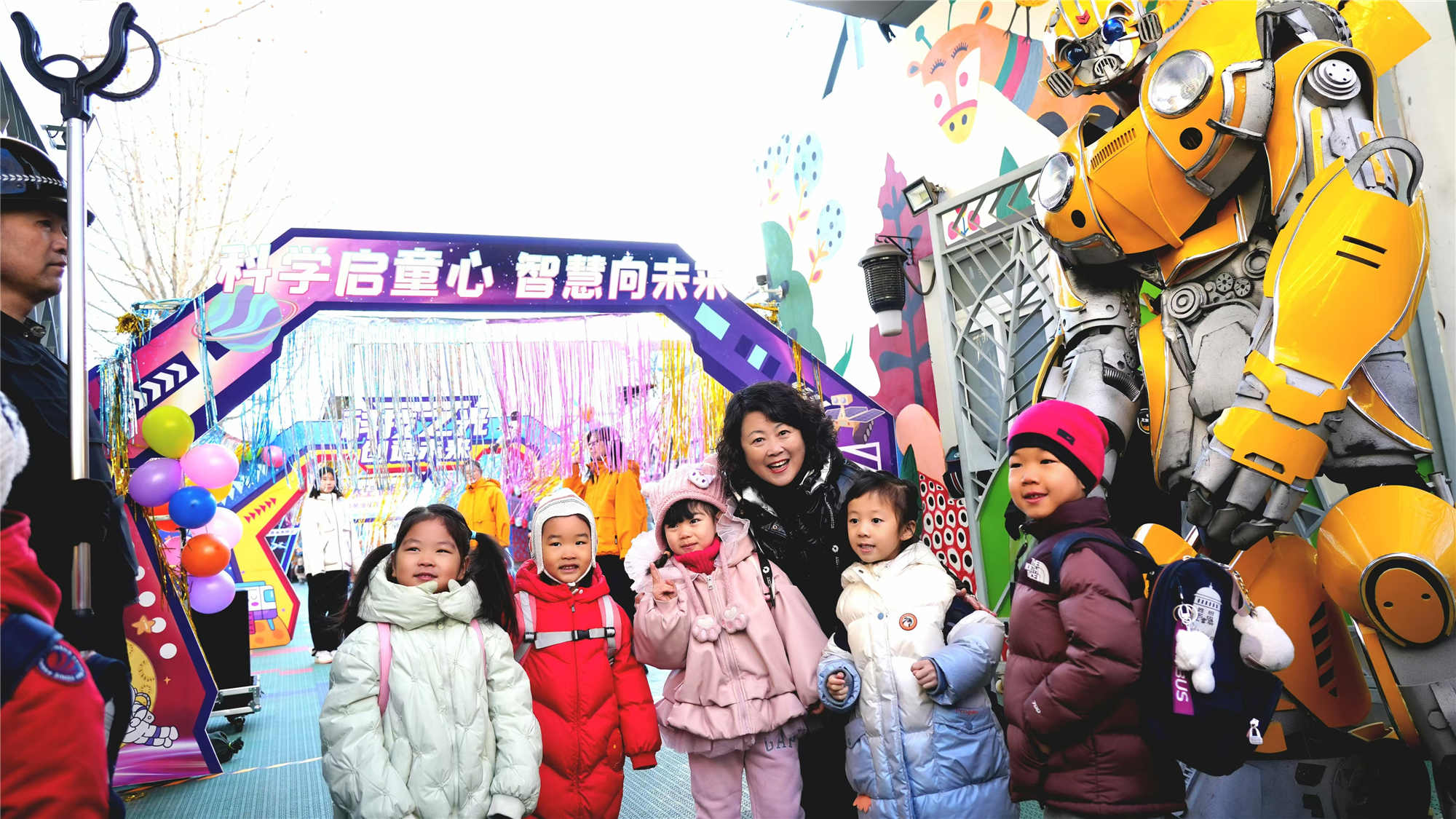 北京市東城區(qū)欣苑幼兒園的小朋友們在老師與機(jī)器人共同迎接下入園。幼兒園供圖