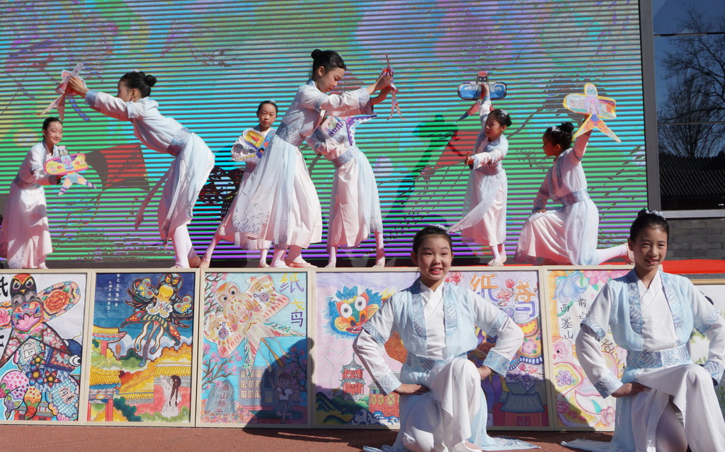 3月24日，府學(xué)胡同小學(xué)學(xué)生在書畫攝影展開幕式上表演歌舞。