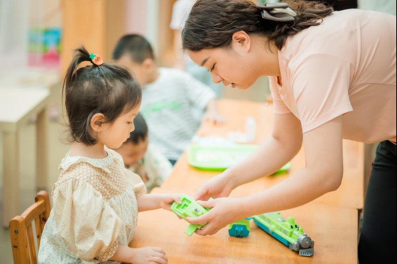 教師與孩子一起玩玩具。園方供圖