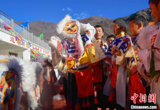圖為加查縣安繞鎮(zhèn)小學(xué)學(xué)生在試穿藏戲面具?！∝暩聛?lái)鬆 攝