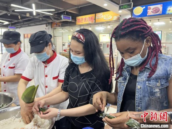 圖為留學(xué)生們嘗試包粽子。　張婧璇 攝