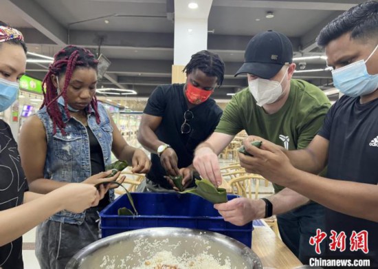 圖為留學(xué)生們嘗試包粽子。　張婧璇 攝