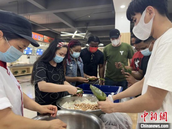 圖為留學(xué)生們嘗試包粽子。　張婧璇 攝