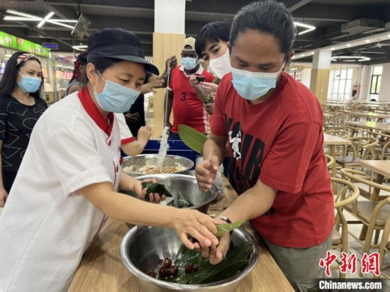 圖為留學(xué)生們嘗試包粽子。　張婧璇 攝