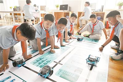 圖為中關(guān)村第三小學(xué)雄安校區(qū)編程社團(tuán)的學(xué)生檢驗(yàn)機(jī)器人的編程效果。新華社記者 李鑫攝