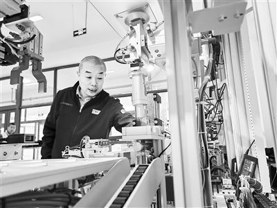 郭海青在檢查車床加工設(shè)備。 受訪者供圖