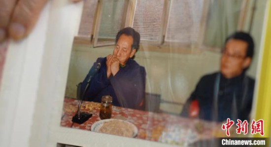 2月7日，劉潤林展示1986年黃旭華(左)在同樂會上吹口琴的老照片。中新社記者 鄒浩 攝