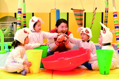 在山東省日照市東港區(qū)一家托幼園，老師陪伴孩子做游戲。新華社發(fā)