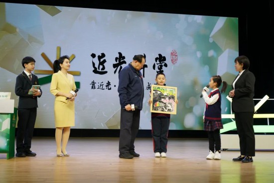 平谷六小版畫(huà)社團(tuán)的學(xué)生代表贈(zèng)送手工作品《平谷彩韻》，展現(xiàn)了平谷桃花海美景。