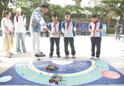 圖為在西安市新城區(qū)華山實驗小學，學生在老師的指導下進行機器人游戲。 新華社記者 張博文攝