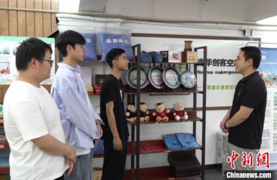 宋宏霖(左三)介紹“大果文創(chuàng)”團(tuán)隊(duì)設(shè)計(jì)的產(chǎn)品。徐志雄 攝